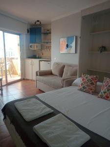 ein Wohnzimmer mit einem großen Bett und einem Sofa in der Unterkunft Apartamentos Benalmadena Toni in Benalmádena