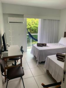 a room with two beds and a desk and a computer at Suíte no Rio Stay Apart-hotel in Rio de Janeiro
