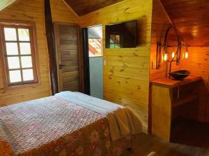 a bedroom with a bed in a wooden room at Chácara Sakura in Santo Antônio do Pinhal