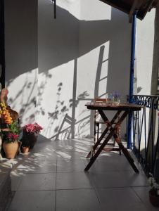 a table and chairs on a balcony with shadows on the wall at The Dolls House in Aldeia de João Pires
