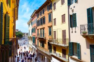 eine Gruppe von Menschen, die eine Straße zwischen Gebäuden entlang gehen in der Unterkunft City Centre Rooms and Apartments in Verona