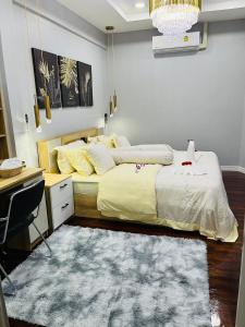 a bedroom with a bed with a desk and a rug at KITJA MY HOME in Hat Yai