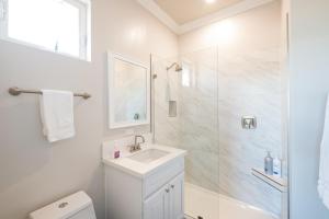 a white bathroom with a shower and a sink at 4048 Stylish condo in Hillcrest Mission Hills in San Diego