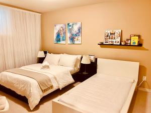 a small bedroom with two beds and two lamps at Willoughby Heights 温馨卧房 in Langley
