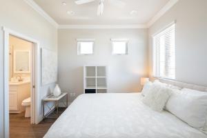 a white bedroom with a bed and a sink at 4048 Stylish condo in Hillcrest Mission Hills in San Diego