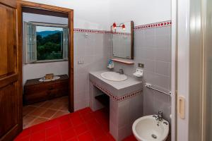 bagno con lavandino, servizi igienici e specchio di Casa Vacanze Etna a Piedimonte Etneo