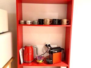 - une étagère rouge avec une cafetière et des tasses dans l'établissement Corbusier, à Marseille