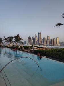 una grande piscina con vista sullo skyline della città sullo sfondo di 7 Palm Jumeirah a Dubai