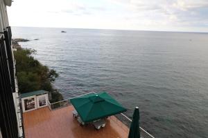 a green umbrella sitting on a deck next to the water at The Marine Hotel in Trabzon