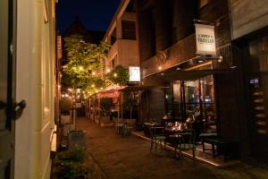 an empty street at night with tables and chairs at Hotel The Happy Traveler in Groningen