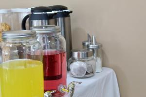 a table with two glass jars and a drink at Johal Mini Hotel -Birmingham City-FREE BREAKFAST in Birmingham