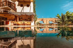 un complejo con piscina y sillas en el agua en Vila Harmonia sua casa na Praia do Preá en Prea