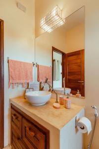 La salle de bains est pourvue d'un lavabo et d'un miroir. dans l'établissement Vila Harmonia sua casa na Praia do Preá, à Prea