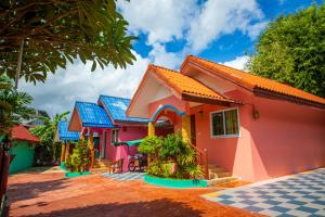 een rij roze huizen met blauwe daken bij Phaithong Sotel Resort in Chalong 