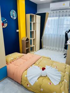 a bedroom with a large bed with two dresses on it at KITJA MY HOME in Hat Yai