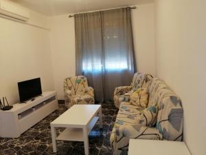a living room with two chairs and a tv at Apartamentos Buendia in Buendía