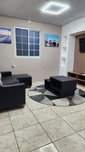 a living room with two couches and a tv at The Layover - 6 mins from the airport, Fully equipped for short and long stays in Kelly Village