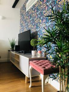 a room with a desk with a tv and plants at Stylish One Bedroom Apartment in Oxford