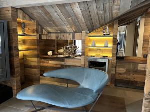 einen blauen Stuhl in einem Zimmer mit Holzwänden in der Unterkunft Luxueux Penthouse avec SPA privé - Cap Crystal Lodge in Tignes