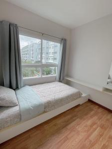 1 dormitorio con cama y ventana grande en Hua hin The Trust condo by Wila en Hua Hin