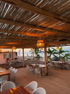 a restaurant with tables and chairs and a view of the ocean at Jessica's Studios & Apartments in Kavos
