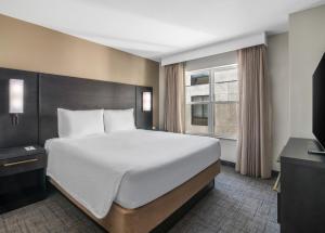 a bedroom with a large bed and a window at Residence Inn Phoenix Glendale Sports & Entertainment District in Glendale