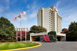 a bus parked in front of a hotel with two flags at Bethesda Marriott in Bethesda