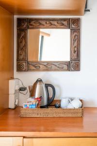 a mirror above a counter with a tea kettle and cups at African Perfection 1 in Jeffreys Bay