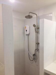 a shower with a shower head in a bathroom at Baansuan Suksangob Farm Stay in Trang