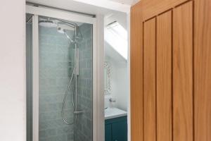 a bathroom with a shower with a glass door at Mariners Cottage, St Ives in St Ives +25 photos
