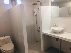a white bathroom with a toilet and a sink at Baansuan Suksangob Farm Stay in Trang +88 photos