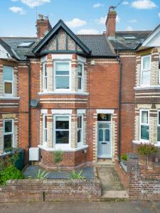 a red brick house with a blue door at Chic Townhouse in the heart of Historical Exeter 5mins to Centre in Exeter