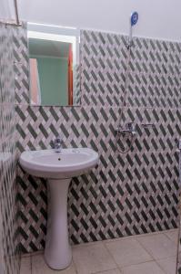 een badkamer met een wastafel en een spiegel bij Royal Wonders Hotel in Moshi