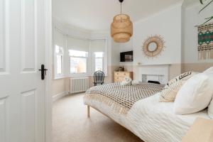 a white bedroom with a bed and a mirror at Chic Townhouse in the heart of Historical Exeter 5mins to Centre in Exeter