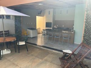 a living room with a table and chairs and a kitchen at Recanto Manga da Rosa - casinha de fazenda no centro da cidade in Olímpia