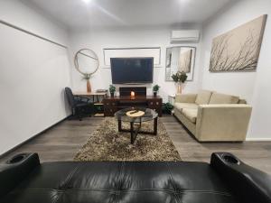 sala de estar con sofá y TV en Private Ensuit in a Luxury Homestay en Caroline Springs