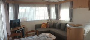 una pequeña sala de estar con sofá y TV en cottage Tangro, en Middelkerke