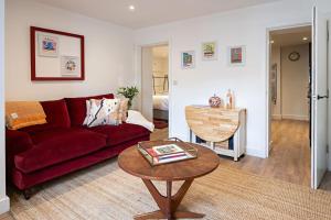 a living room with a red couch and a table at The Courtyard Apartment with parking in Ilfracombe