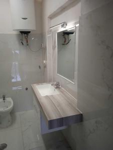 Baño blanco con lavabo y espejo en Happy holidays in Pompei, en Pompeya