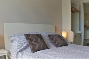 a bedroom with a bed with a pillow on it at Stylish Seaview House with Hot Tub in Hythe