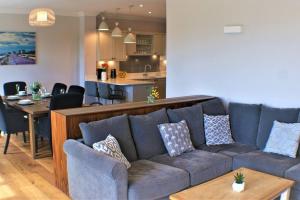 a living room with a couch and a kitchen at Stylish Seaview House with Hot Tub in Hythe