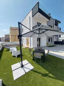 a group of chairs and a table with an umbrella at Sirene452 - apartment - in Torvaianica
