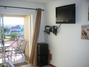 a room with a flat screen tv on a wall at Waterside Living MS22 in Jeffreys Bay