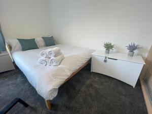 a bed with pillows on it in a room at Modern apt next to Temple meads and Bristol Centre in Bristol