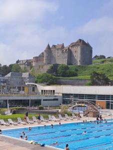 une grande piscine avec un château en arrière-plan dans l'établissement Studio Saint Rémy Dieppe, à Dieppe