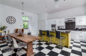 a kitchen with a wooden table and black and white checkered floor at Westwood Cottage in Dundee