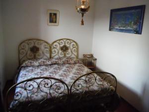 a bed in a bedroom with a wrought iron bed frame at Gravedona Village House in Gravedona