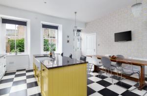 a kitchen with a yellow island and a table at Westwood Cottage in Dundee