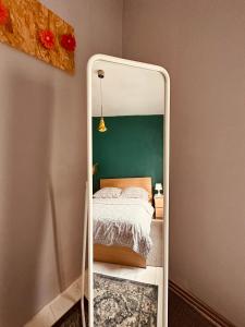 een spiegel voor een slaapkamer met een bed bij Stare Miasto in Zielona Góra