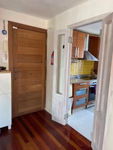 een keuken met een deur naar een keuken met een aanrecht bij Casuca Los Cencerros in Santander